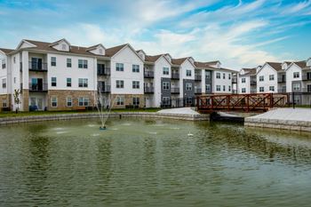 A row of apartment buildings with a fountain in the foreground.